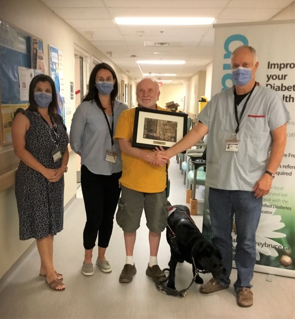 Donald Anderson being presented with the insulin half-century award by Brightshores diabetic clinic staff.