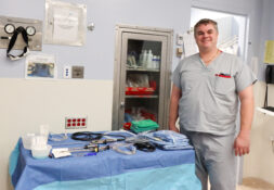 Dr. Wignall standing with surgical supplies.